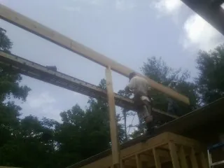 Carpenter setting a ridge beam over a new addition frame — Ice Dam Removal by Roofing Brothers in Laclede