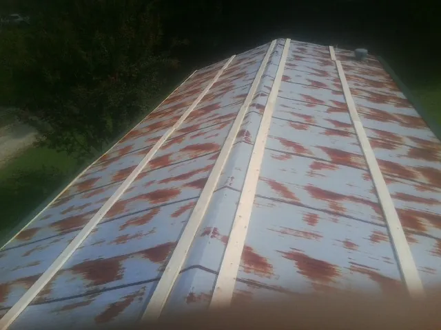 Rusted metal roof panels with new wood purlins before replacement — Storm Damage Roof Repair in Laclede by Roofing Brothers