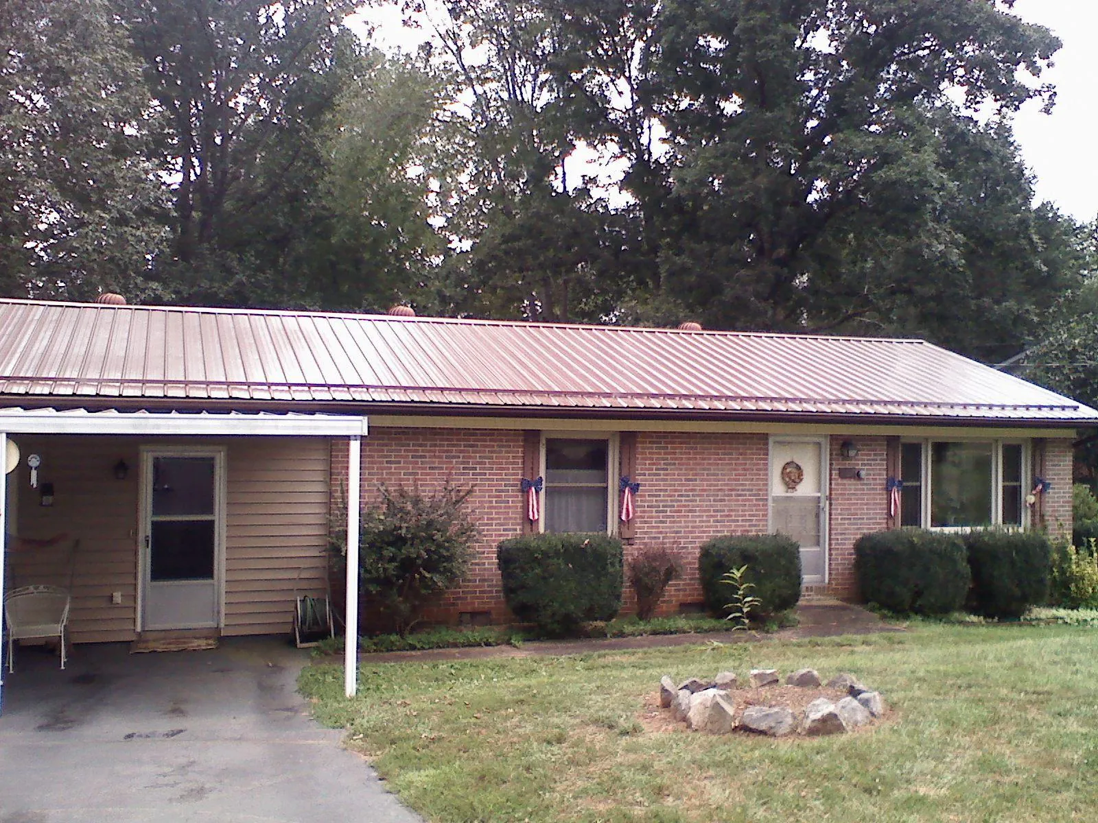 Bronze metal roof and carport on a brick ranch home — Roof Repair work by our crew in Laclede